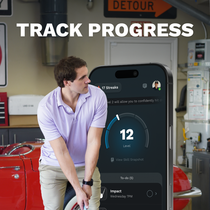 Man in a garage looking at a smartphone displaying app progress with text 'Track Progress'.