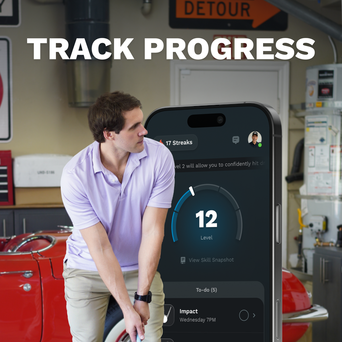 Man in a garage looking at a smartphone displaying app progress with text 'Track Progress'.