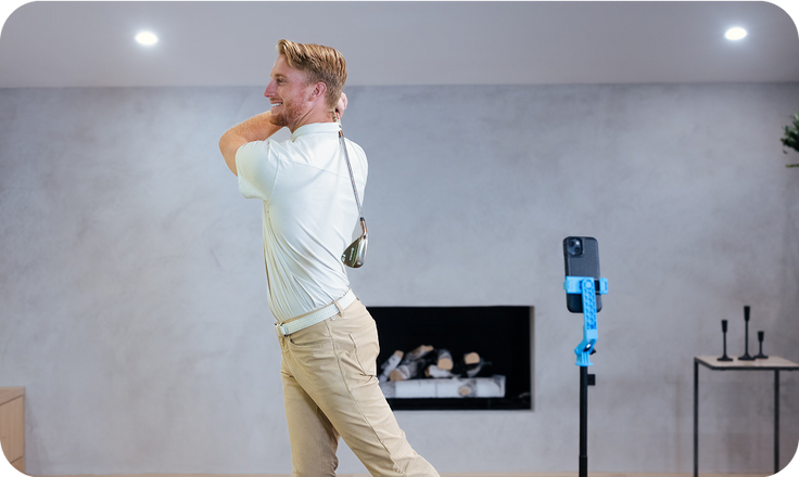 Man standing in a room using a Benchmark Golf Simulator